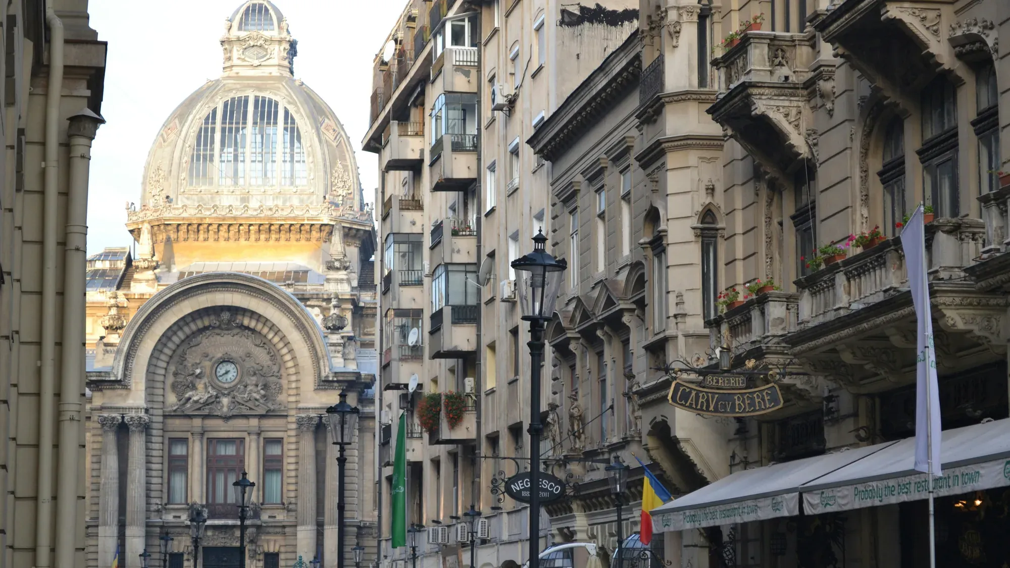 A narrow street in Bucharest's old town, ending at the glass-domed CEC Palace