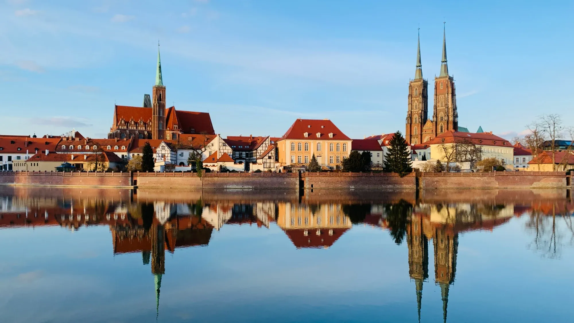 Historic buildings reflected in the river in Wrocław
